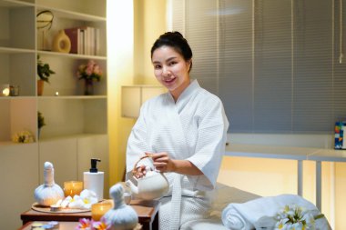 Beyaz bornozlu güzel bir kadın kaplıcada spa işlemleri yaptıktan sonra dinleniyor, çay içiyor. Zarif kadın rahatlıyor, iç huzurunu ve dengesini buluyor..