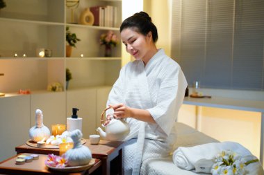 Beyaz bornozlu güzel bir kadın kaplıcada spa işlemleri yaptıktan sonra dinleniyor, çay içiyor. Zarif kadın rahatlıyor, iç huzurunu ve dengesini buluyor..