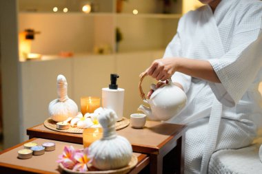 Beyaz bornozlu güzel bir kadın kaplıcada spa işlemleri yaptıktan sonra dinleniyor, çay içiyor. Zarif kadın rahatlıyor, iç huzurunu ve dengesini buluyor..