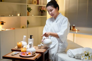 Beyaz bornozlu güzel bir kadın kaplıcada spa işlemleri yaptıktan sonra dinleniyor, çay içiyor. Zarif kadın rahatlıyor, iç huzurunu ve dengesini buluyor..