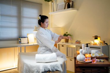 Bornozlu kadın güzellik salonundaki cilt bakım rutini sırasında gerekli yağı sürüyor. Güzellik merkezi konsepti. Vücut bakımı.