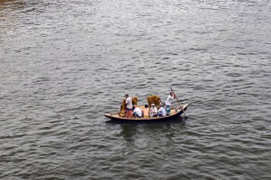 Sakin suyun üzerinde seyahat eden küçük ahşap bir tekne.
