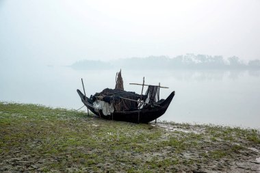 Old Wooden Boat Resting on Lakeshore During Foggy Morning