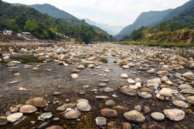 Tranquil Mountain River Scene With Pebble Beach, Forest, and Distant Ranges