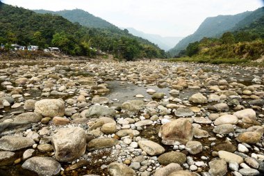 Tranquil Mountain River Scene With Pebble Beach, Forest, and Distant Ranges