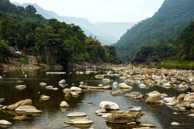 Tranquil Mountain River Scene With Pebble Beach, Forest, and Distant Ranges