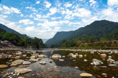 Tranquil Mountain River Scene With Pebble Beach, Forest, and Distant Ranges