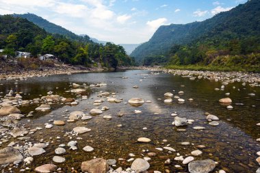 Tranquil Mountain River Scene With Pebble Beach, Forest, and Distant Ranges