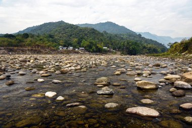 Tranquil Mountain River Scene With Pebble Beach, Forest, and Distant Ranges
