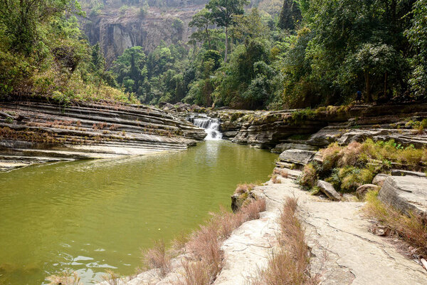 Tranquil River Flowing Through a Rocky Gorge Surrounded by Lush Green Foliage