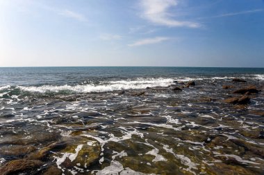 Mavi Gök Altındaki Rocky Shoreline Taşlarda Yumuşak Dalgalar Kırıyor