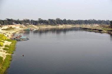 Sahil boyunca teknelerle sakin nehir manzarası ve insanların keyifli bir gün geçirmesi.