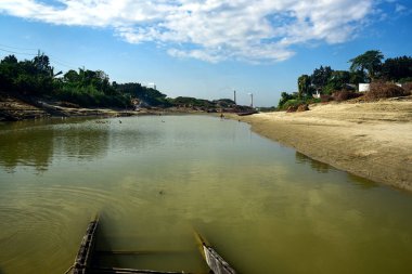 Sükunet Nehir Kıvrımında Sandy Bank, Yeşil Sebze ve Sessiz Su Yolu Üzerinde Açık Mavi Gökyüzü