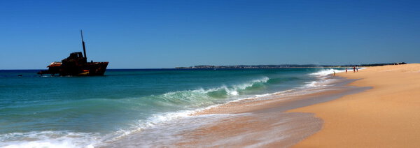 Морской пейзаж песчаного пляжа с кораблекрушением
