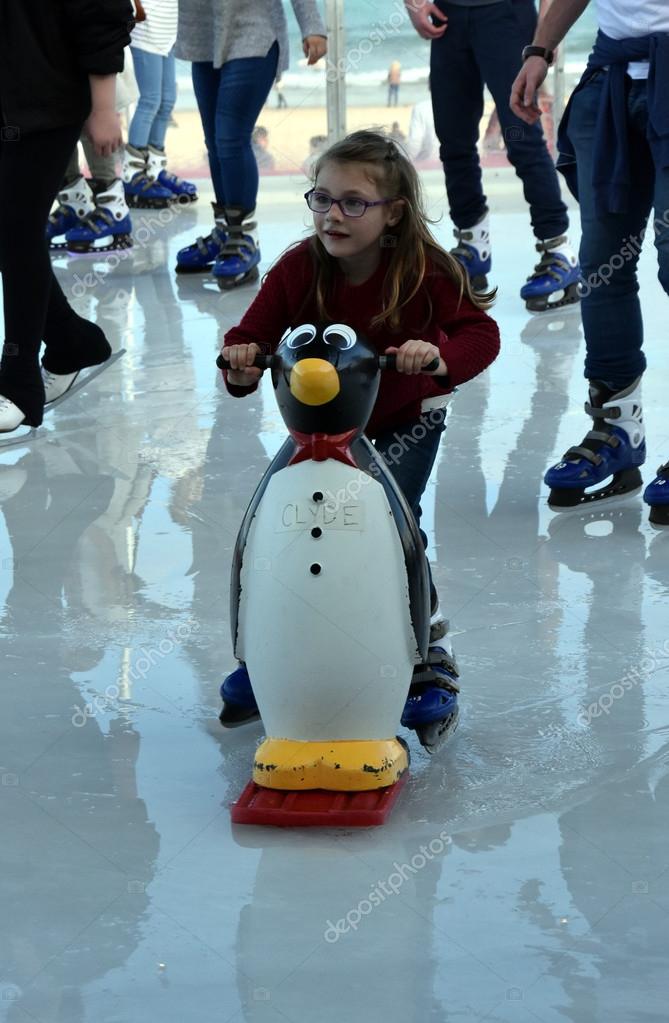 Ice skating penguin aid Girl skating with Penguin Skate Aid Stock Editorial Photo