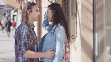 Sevimli kız ve erkek uzun saçlı sokakta öpüşme