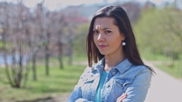 Una chica parada en el parque está enojada. — Vídeos de Stock