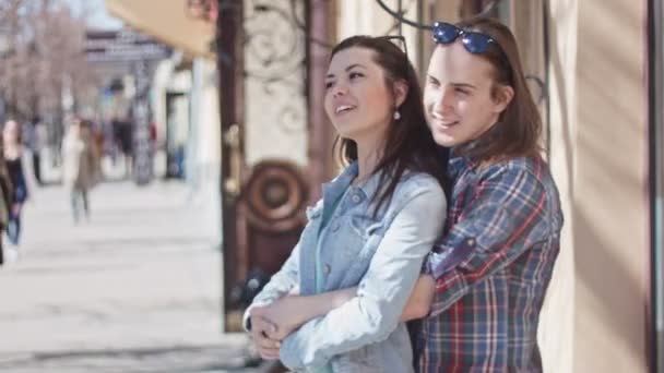Söt flicka och en pojke med långt hår poserar på gatan, titta på attraktion — Stockvideo
