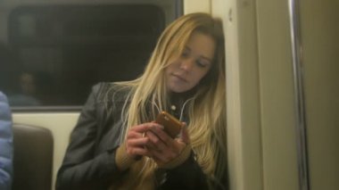 Saç kullanım gadget metro ile deri ceketli uzun sarı saçlı çekici yorgun kız düzeltiyor