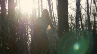 Kızıl saçlı gözlük ile güzel kız ormanda önden gider