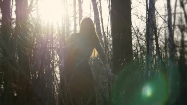 Belle fille aux cheveux roux portant des lunettes passe à travers les bois avant — Video