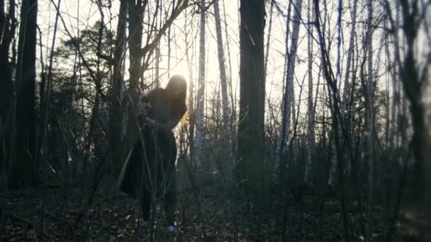 Belle fille aux cheveux roux portant des lunettes passe à travers les bois avant — Video