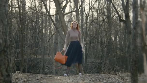 Vacker flicka med rött hår glasögon dans i parken våren — Stockvideo