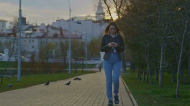 Sevimli genç kız parkta gece karanlığında yürür.