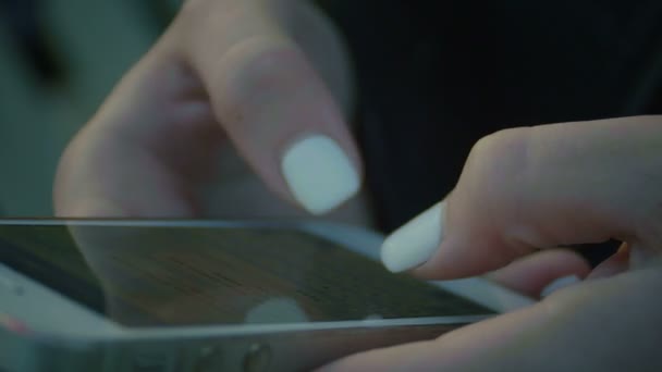 Carino ragazza utilizza gadget seduto sul parco giochi al tramonto estremamente da vicino — Video Stock