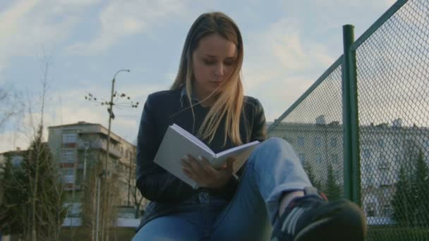 Linda chica joven escribiendo diario sentado en el patio al atardecer — Vídeo de stock