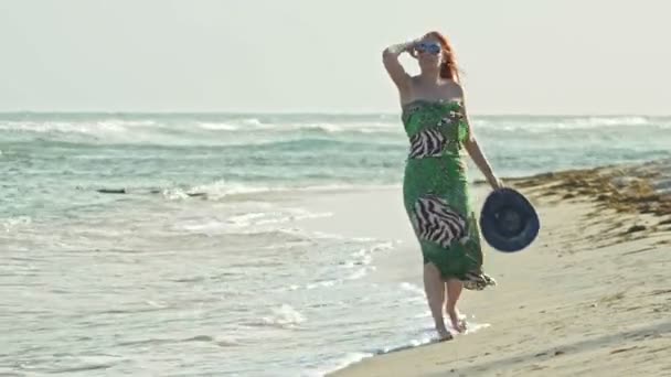 Junge Frau im langen Kleid lauscht einer Muschel am Meer, — Stockvideo