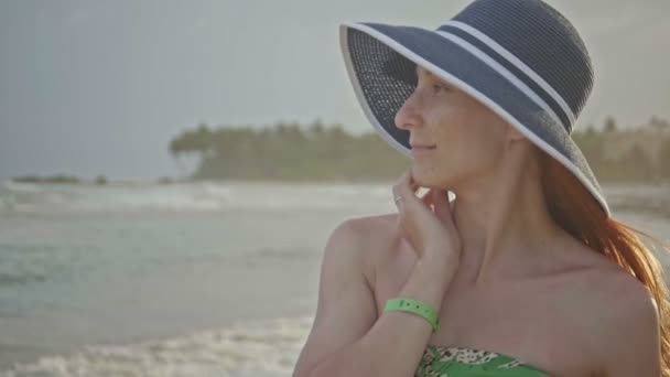 Primer plano retrato de una hermosa joven con pecas en sombrero posando en la playa tropical de cámara lenta, República Dominicana — Vídeos de Stock