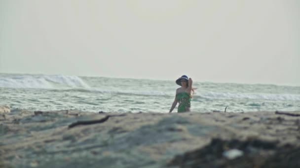 Jonge vrouw In lange jurk houdt de schoenen en wandelen langs de zee gaat over de horizon, slow-motion — Stockvideo