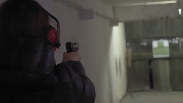 Frau schießt mit Waffe in Schießstand. Zeitlupe — Stockvideo