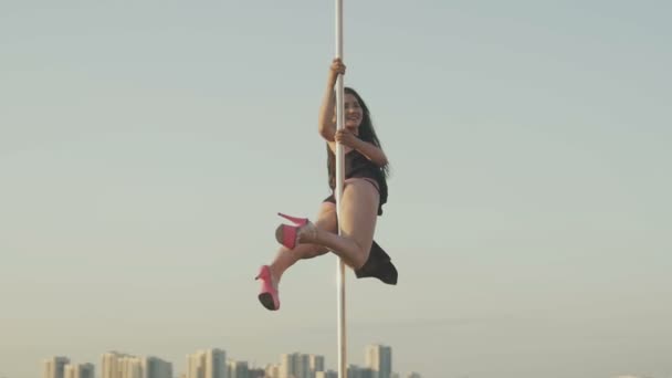 Apto chica atractiva poledancer colgando en el poste en el día de verano en el escenario de baile portátil sobre el horizonte — Vídeos de Stock