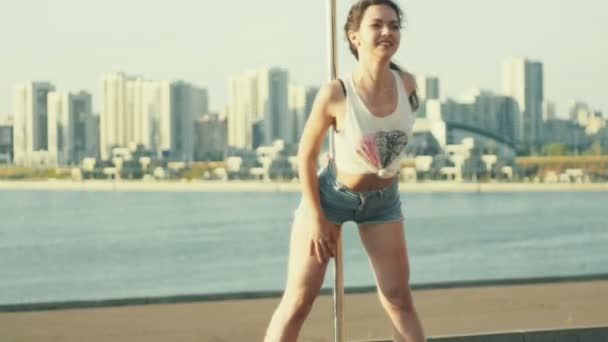 Sexy young girl posing on the pole at sunset on portable dancing stage over the skyline — Stock Video