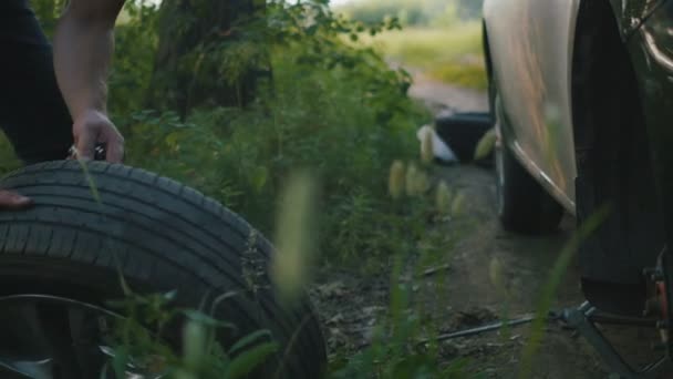 A strong man takes the wheel of a car in the woods, close up — Stock Video