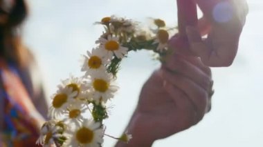 Genç kadın papatya çayırda çiçek çelenk toplar, kadar güneşin önünde yakın