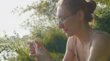 Genç kadın bir ormanda Shawarma Burito yemek için bir iştahla bardaklarda ince