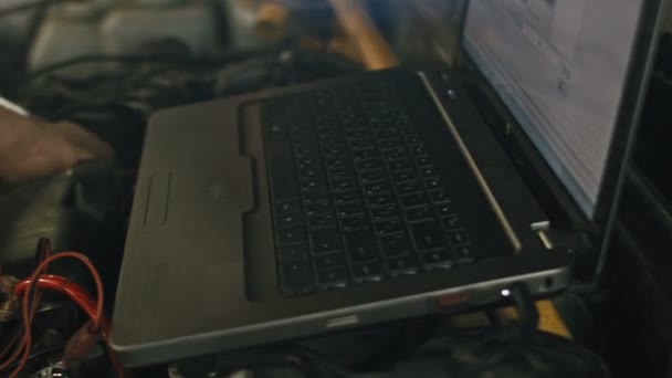 Υπηρεσία αυτοκινήτων, διαγνωστικά υπολογιστή: μηχανικός επισκευάζει τη ζημιά χρησιμοποιώντας τον υπολογιστή στην υπηρεσία αυτοκινήτων, ρυθμιστικό, κοντά επάνω — Αρχείο Βίντεο