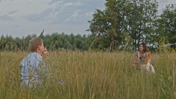 Доросла пара позує за жінкою-фотографом під час фотосесії на відкритому повітрі — стокове відео