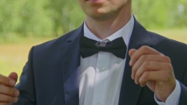 Damat Beyaz gömlekli bir papyon önden, açık, closeup koyar.