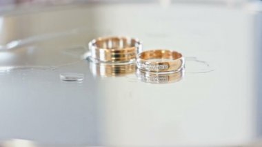 İki alyans ayna masada su damlaları