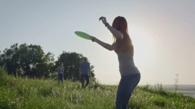 Frizbi çayır üzerinde yaz akşamları, ağır çekim atma aile ile şirin kız