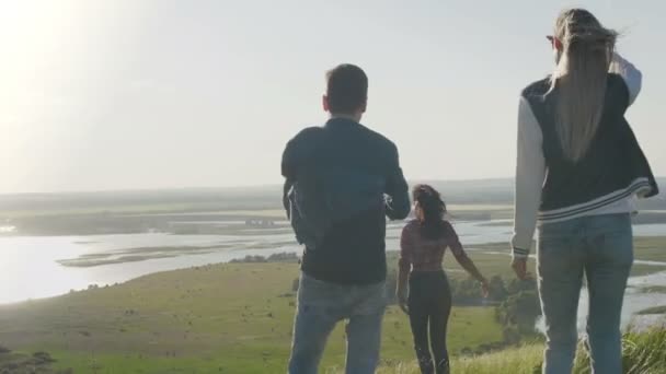 Groupe de jeunes amis heureux marchant sur une haute colline le soir d'été — Video