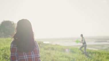 Mavi Jeans yaz günü güneşin yavaş hareket doğru yüksek tepe çayırda bir frizbi atma genç kadın