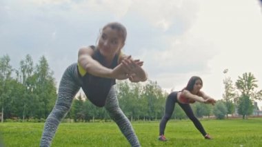 Genç çekici fitness kadınlar vücut Park için esnek egzersiz yapıyor