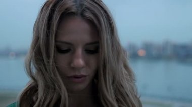 Poz ve kamera için gün batımında cityscape üzerinde seyir çekici genç kadın