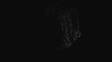 Genç çift: el feneri ile insan siluetleri mağarada girin