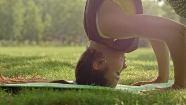 Aantrekkelijke fitness jonge vrouw maken van yoga houdingen. HEADSTAND, dolly schot — Stockvideo